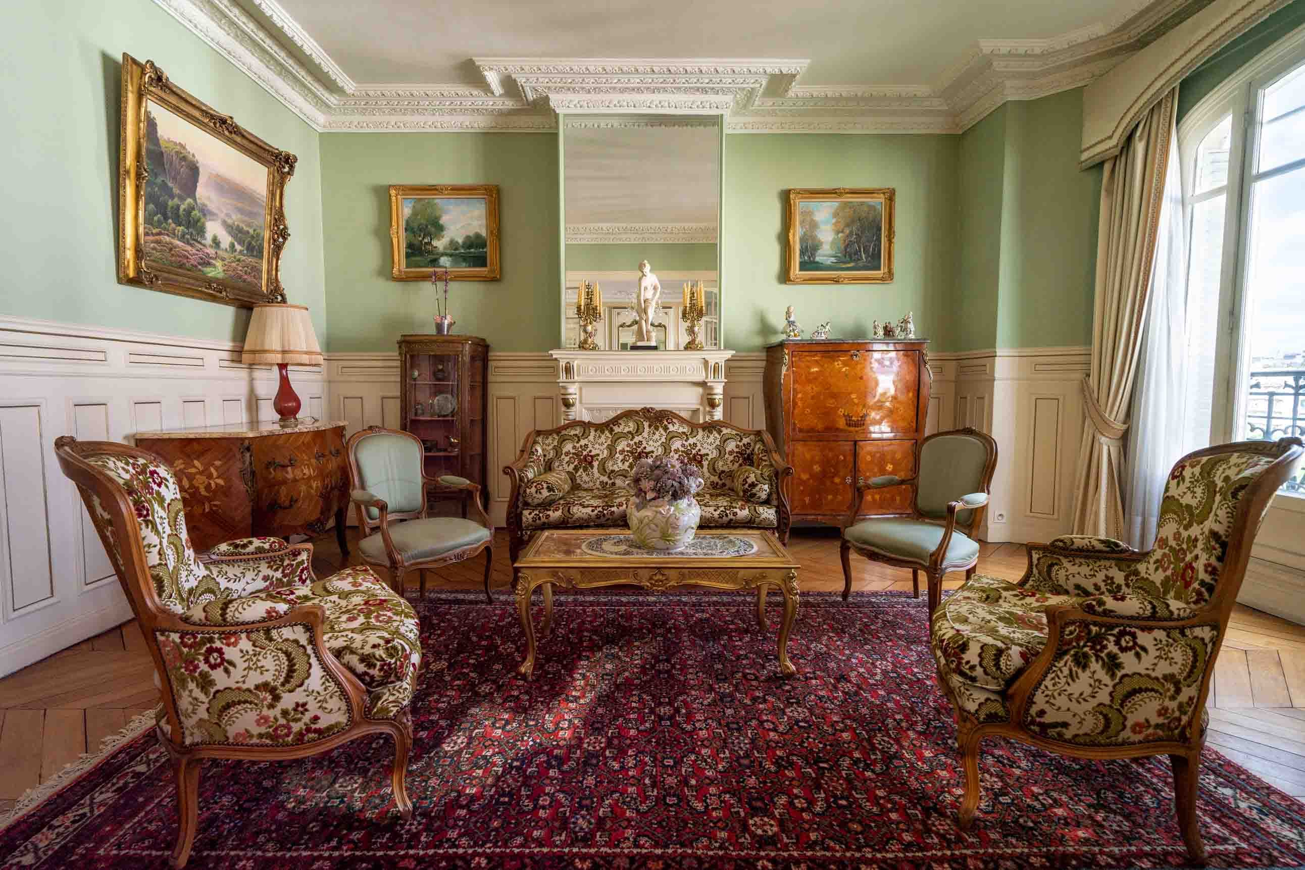 Living room with almond green walls, sofa and armchairs