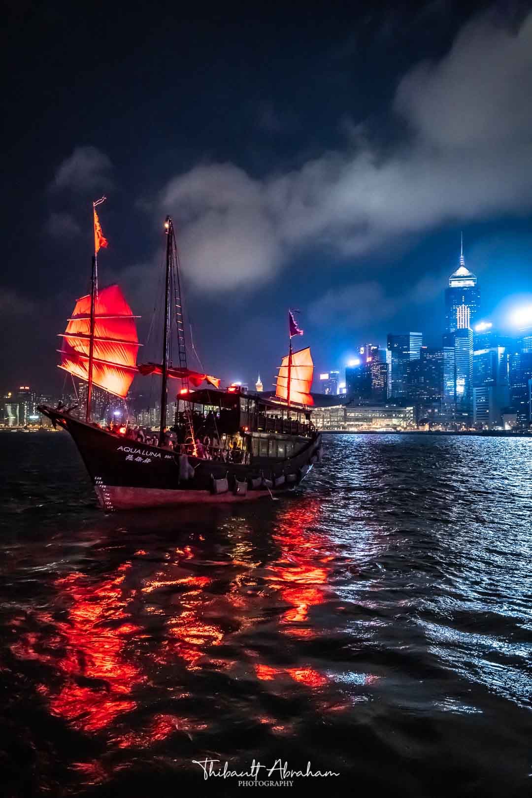 Le bateau Aqualuna vogue la nuit sur une rivière à Hong Kong