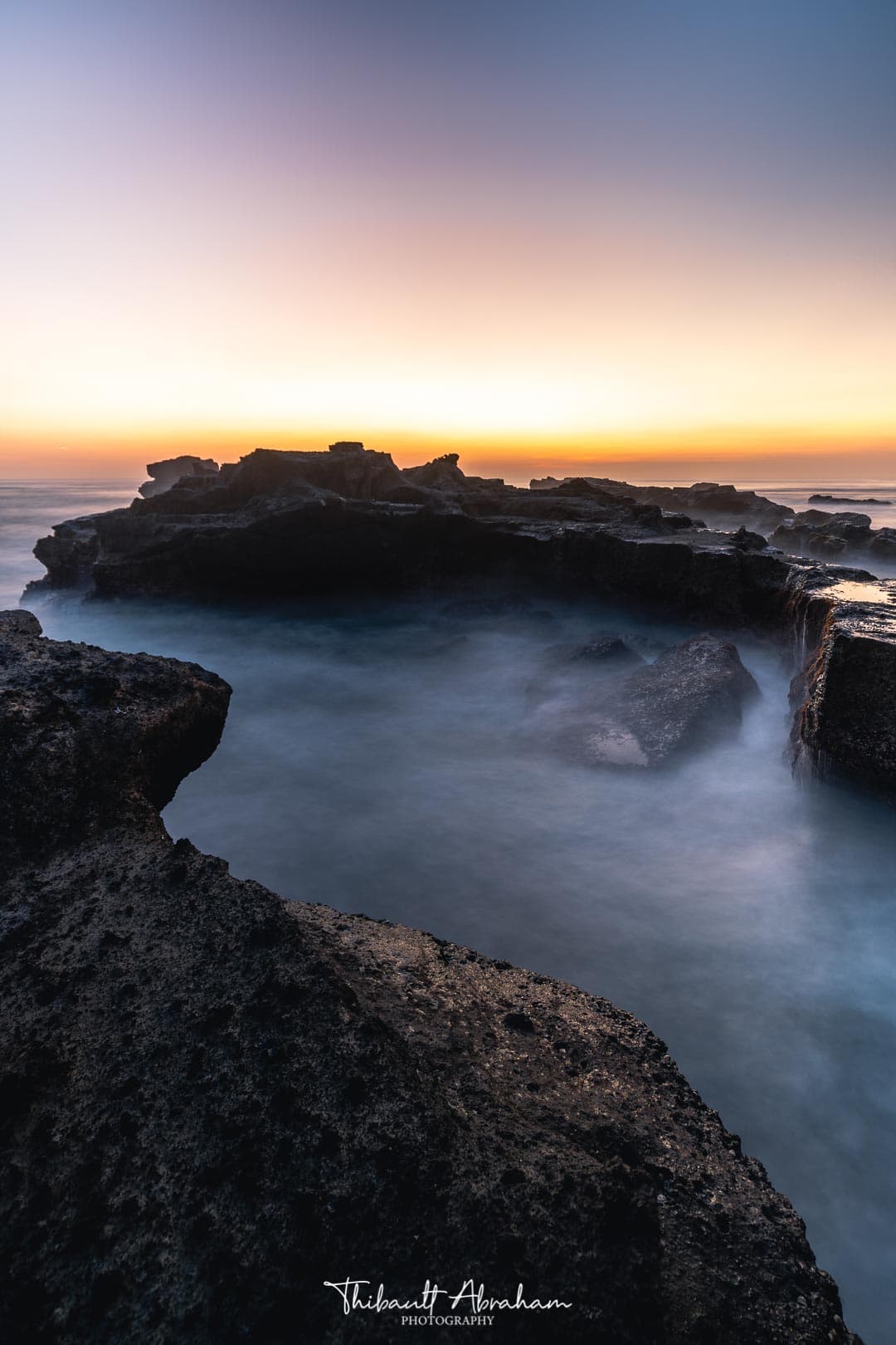 Coucher de soleil mystique sur une plage de rochers à Bali