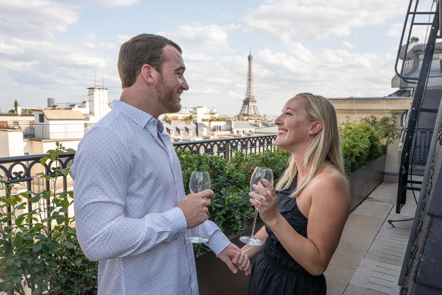 Un couple se tient tendrement la main lors d'une demande en mariage intime au Peninsula à Paris.