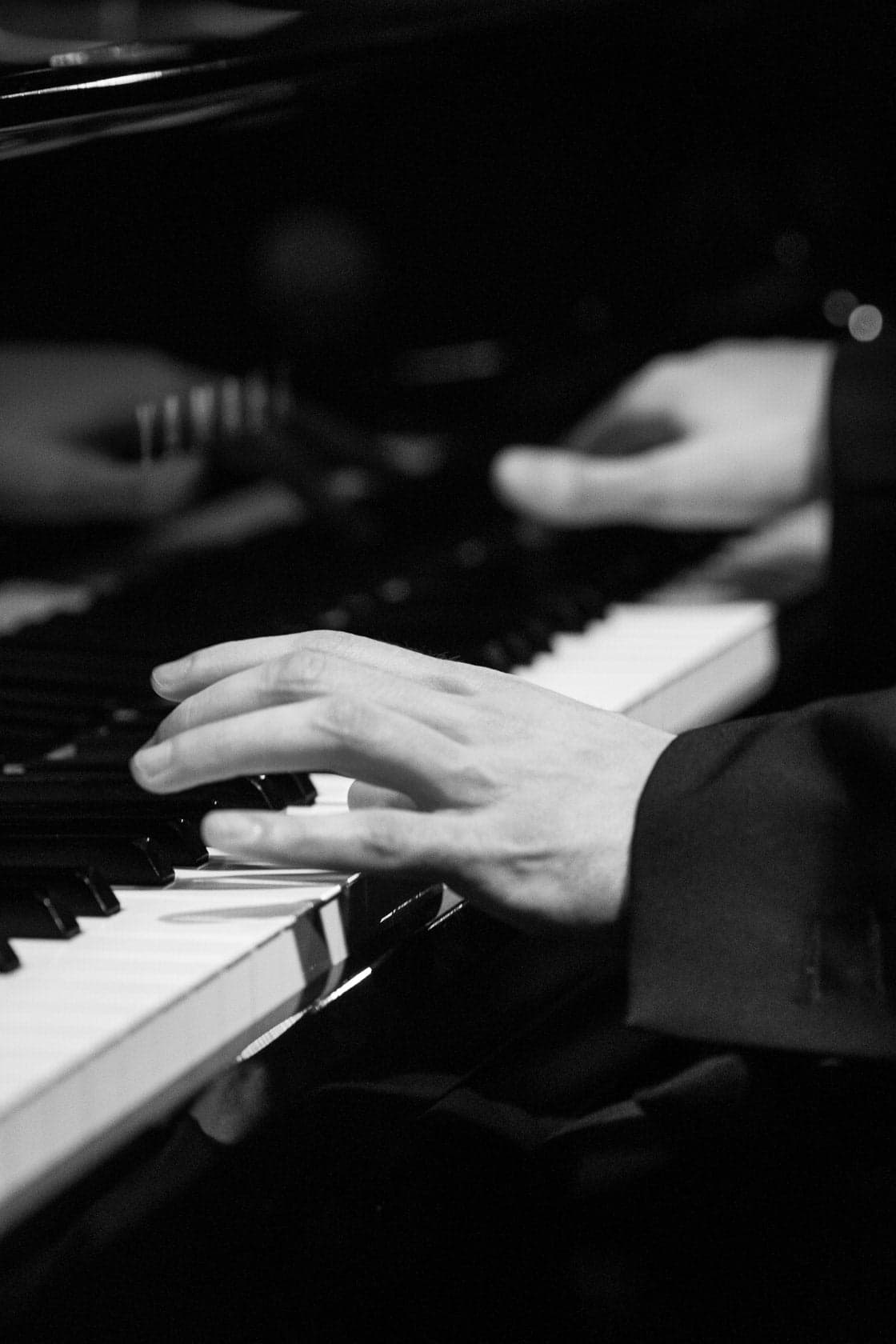 Gros plan des mains d'Aurélien Froissart au piano en concert