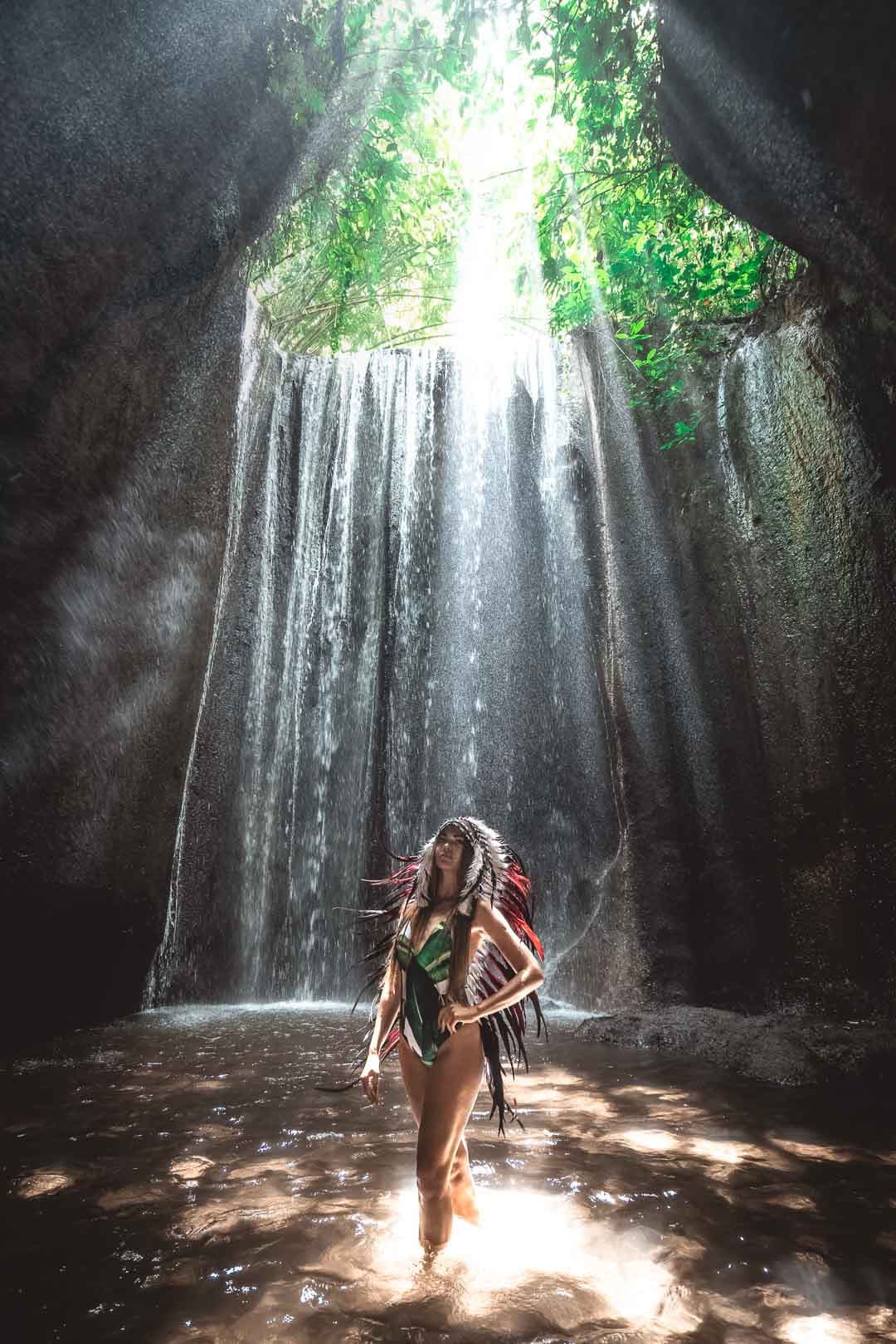 Femme portant une coiffe Indienne traditionnelle devant la cascade Tukad Cepung à Bali