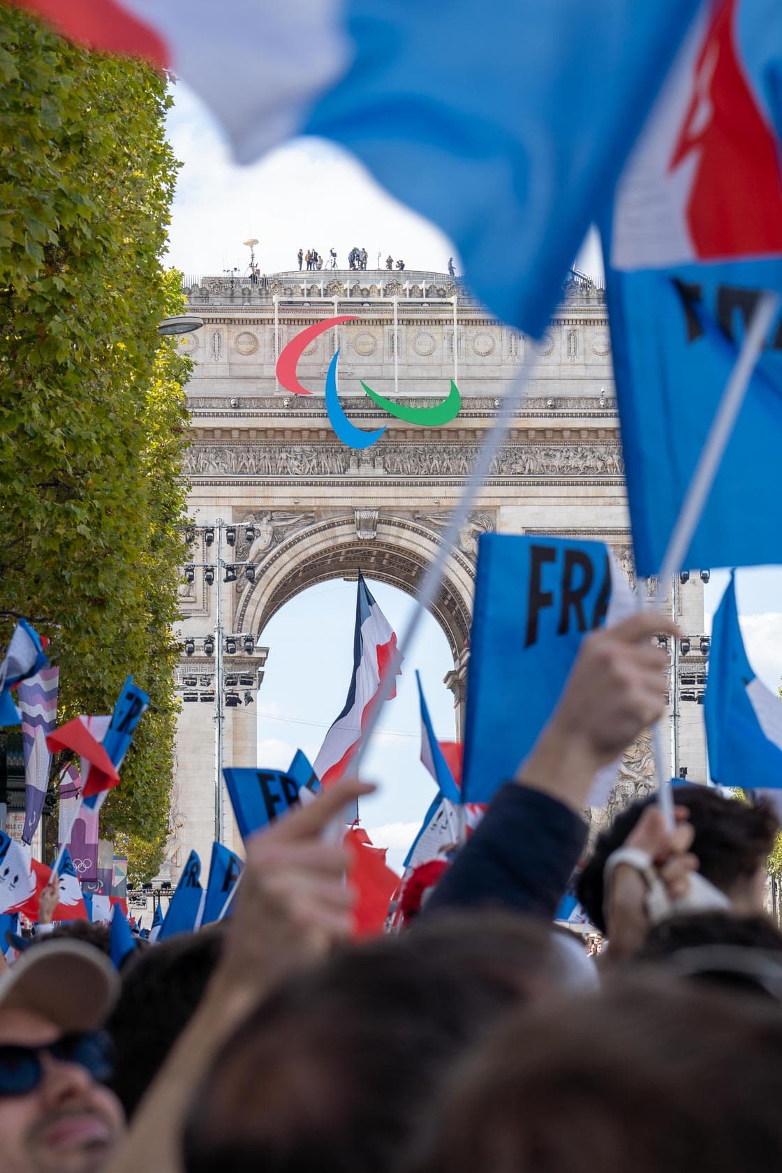 Arc de Triomphe décoré pour la Parade des Champions et drapeaux français flottants dans les airs