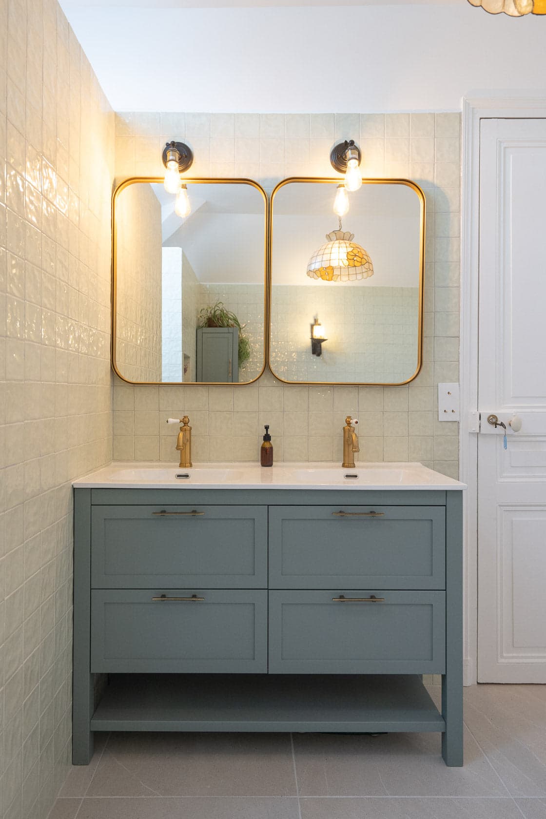 Salle de bain double vasque, miroirs arrondis dorés et faïence vert amande