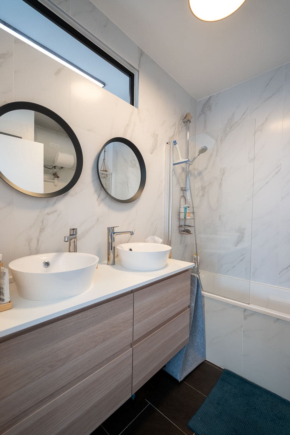 Salle de bain en marbre blanc, double vasque ovale et douche vitrée