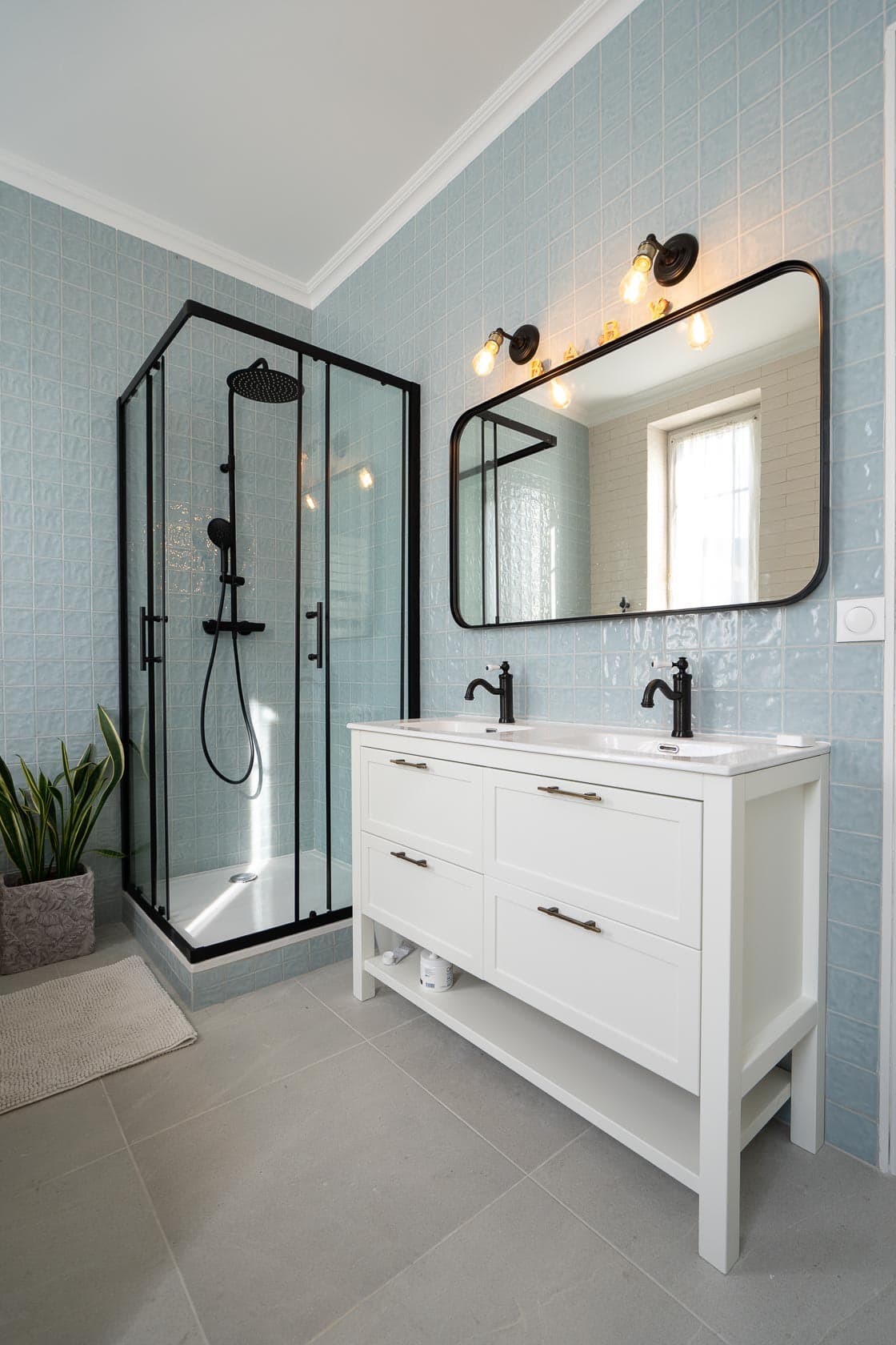 Salle de bain carrelage bleu ciel, douche italienne noire et double vasque