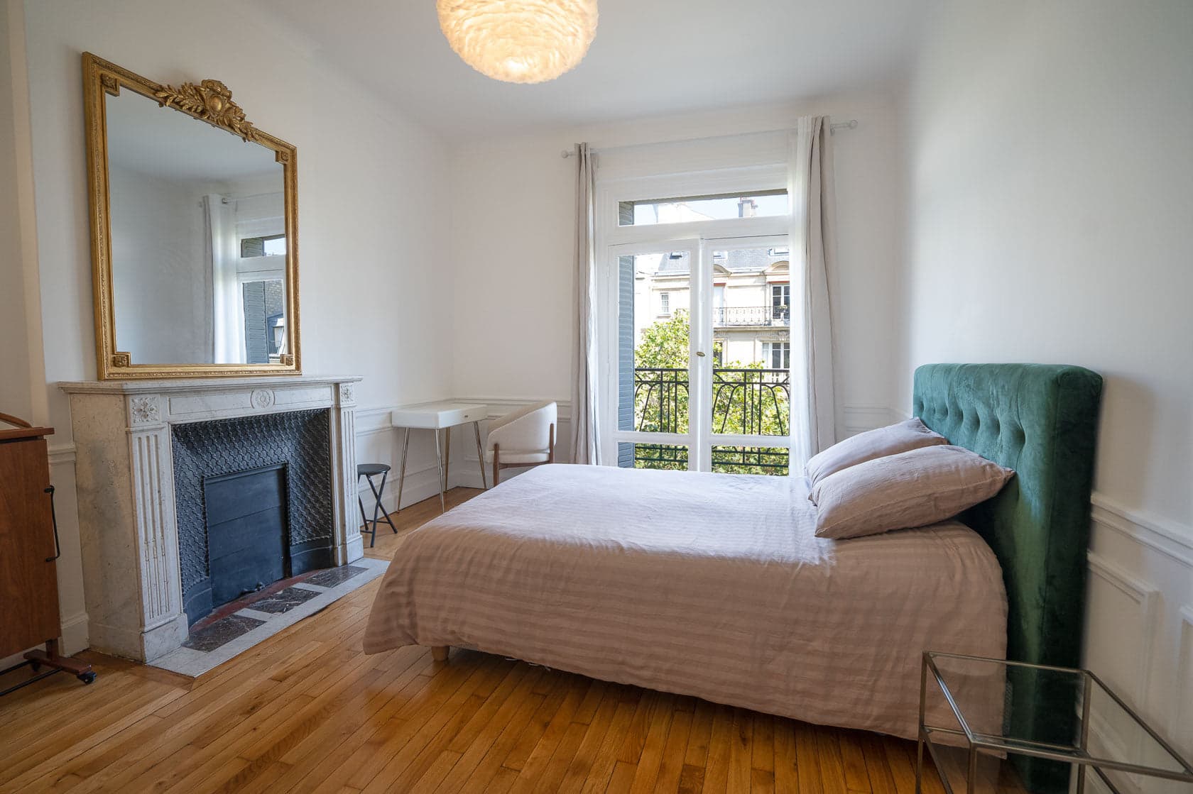 Chambre haussmannienne, cheminée en marbre et miroir doré, tête de lit velours vert
