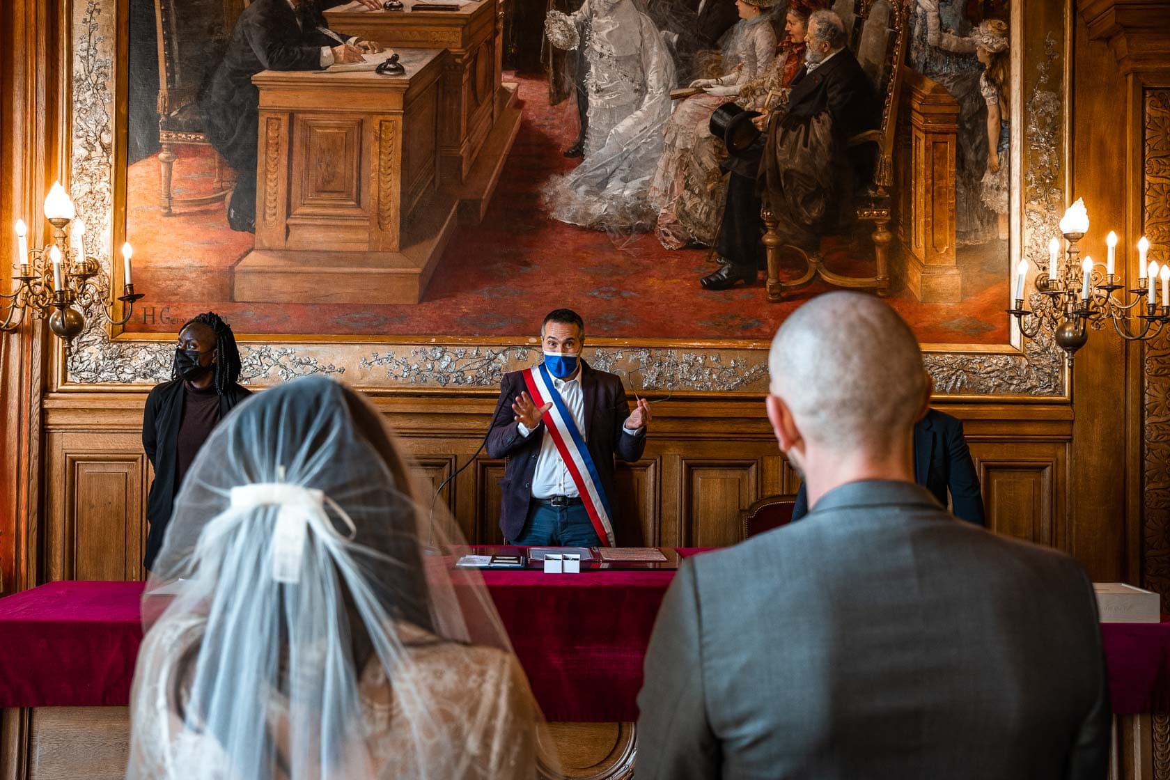Les mariés devant le Maire du 19ème lors de leur cérémonie civile à Paris, capturant l'engagement.