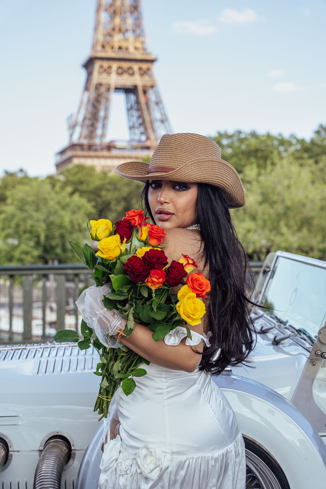 Portrait de femme avec bouquet devant une voiture de collection au pont de Bir-Hakeim avec la Tour Eiffel