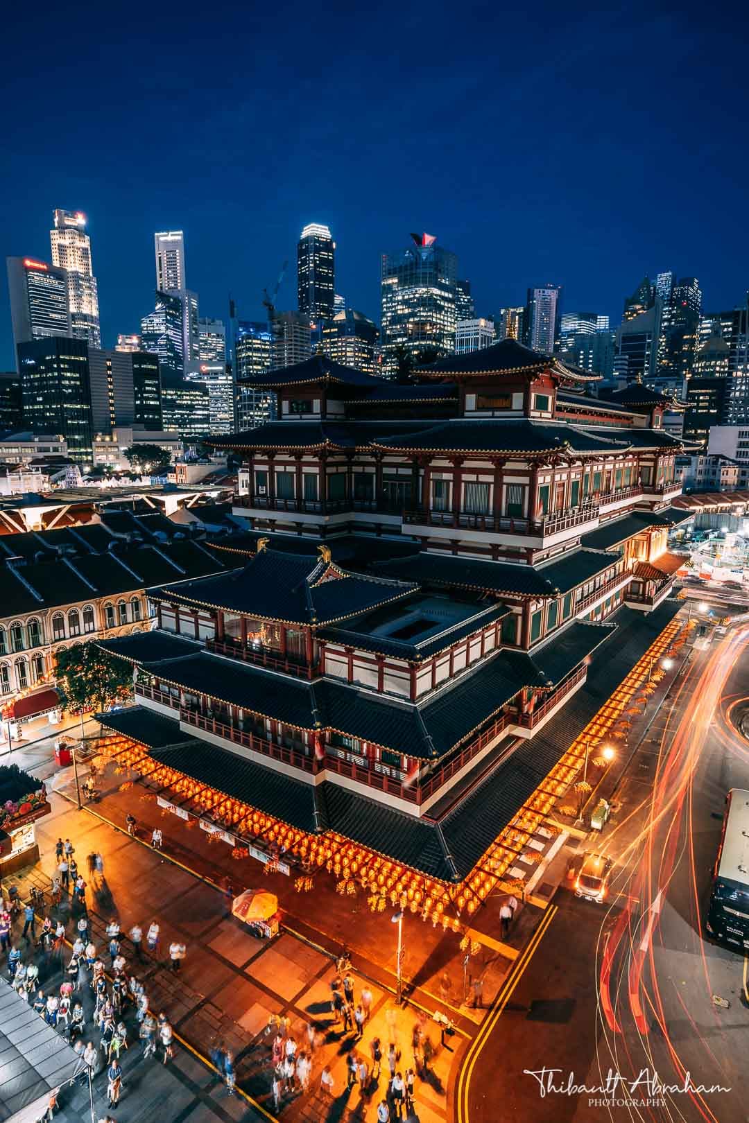 Vue en hauteur du Temple de la dent de Buddha éclairé la nuit, avec le district financier au loin, à Singapour