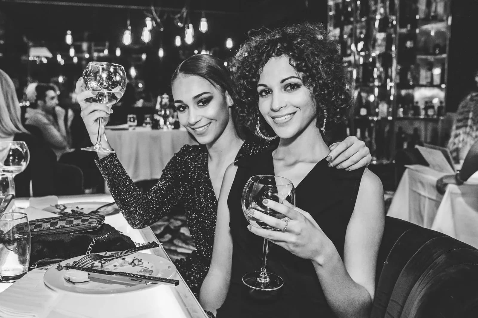Deux amies trinquant au bar, en noir et blanc