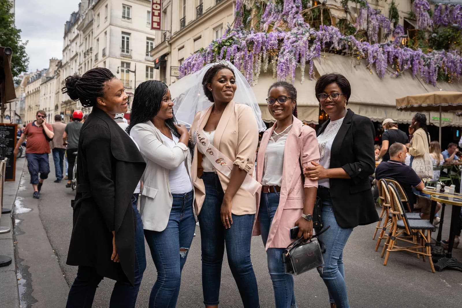 Groupe d'amies avec la future mariée sur une terrasse fleurie de glycine