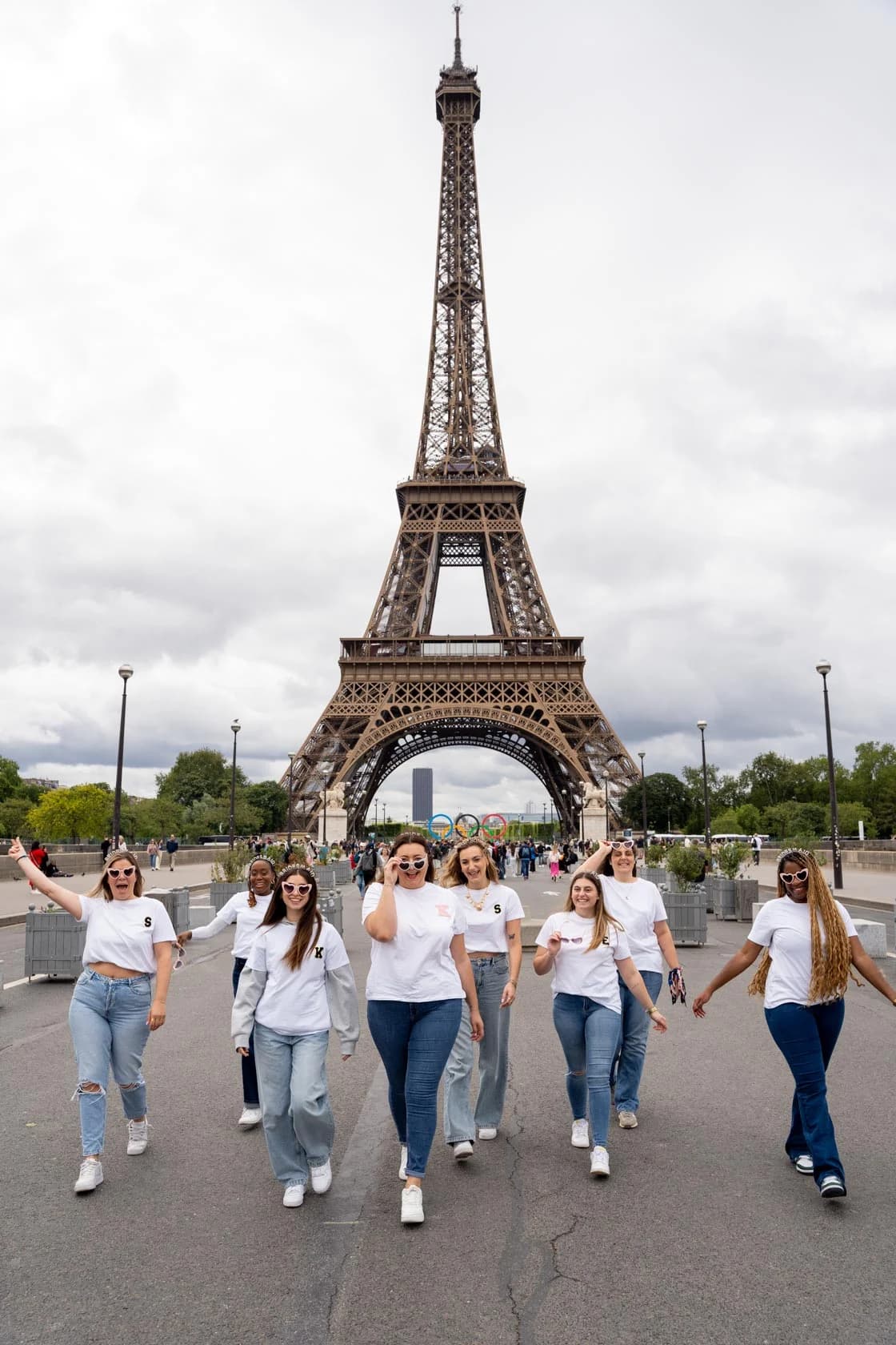 A group of friends walking towards the camera on the Trocadero esplanade, with the Eiffel Tower in the background, creating a joyful atmosphere.