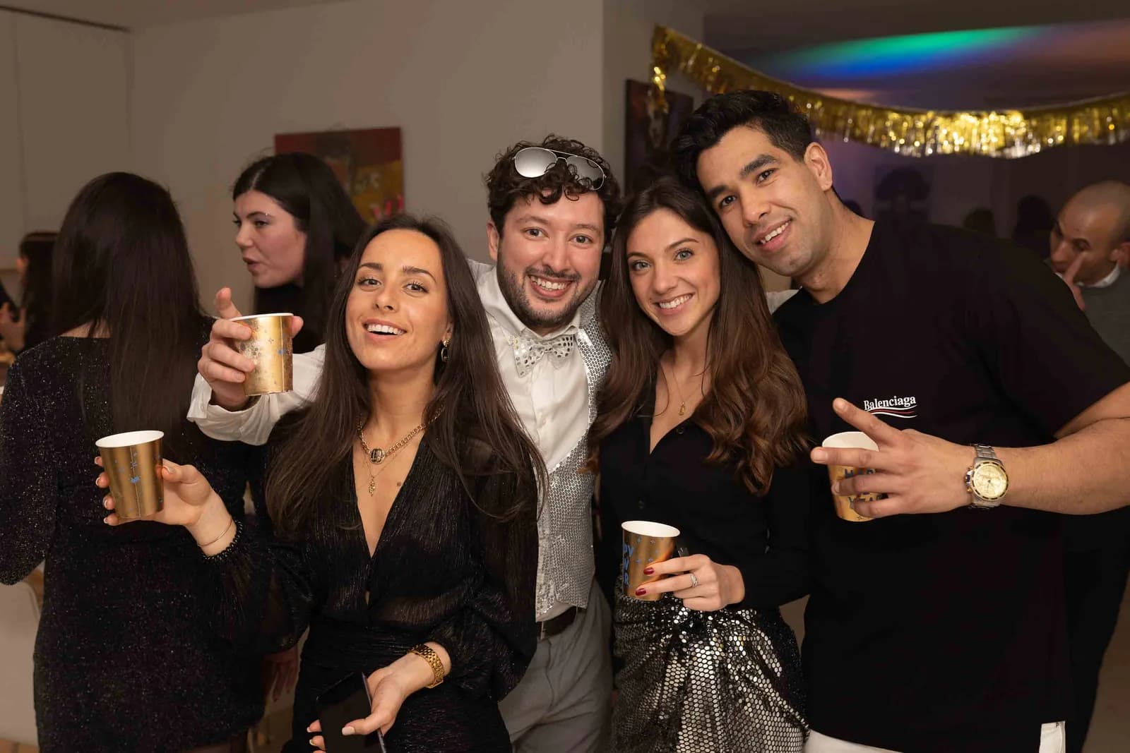 Quatre amis avec des gobelets dorés pour le Nouvel An