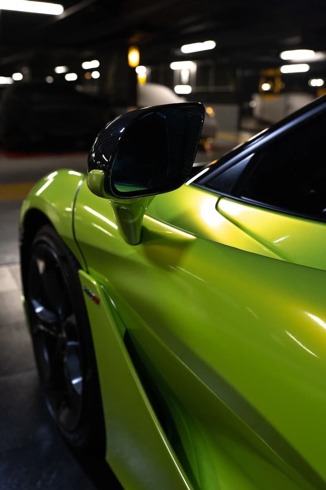 Détail du rétroviseur en carbone dans un parking