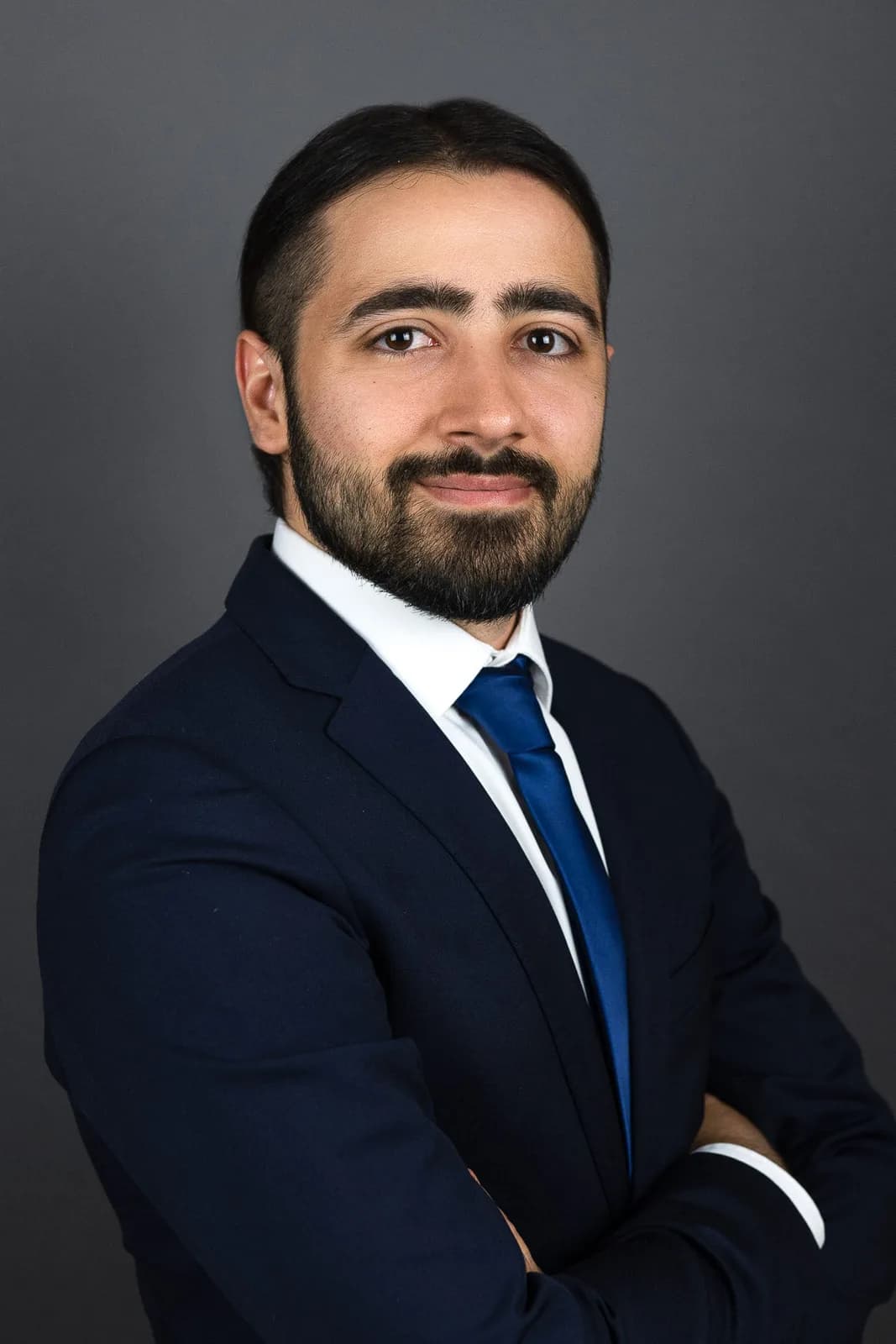 Homme barbu en costume marine et cravate bleue