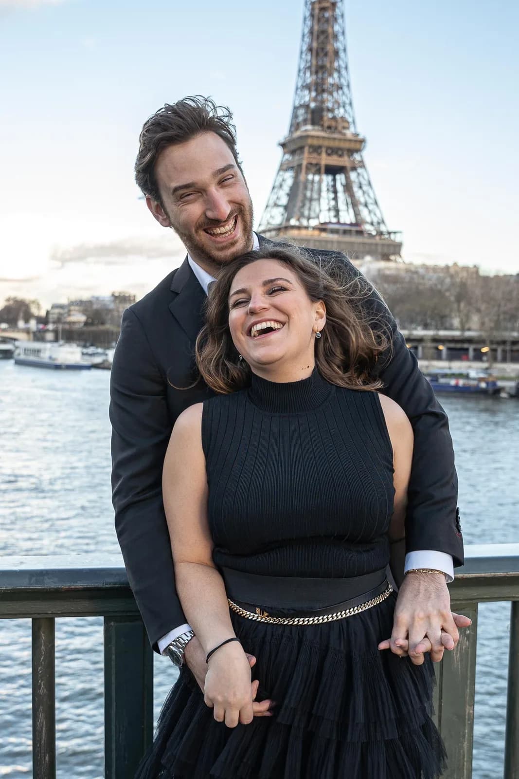 Couple riant sur un quai, Tour Eiffel en fond