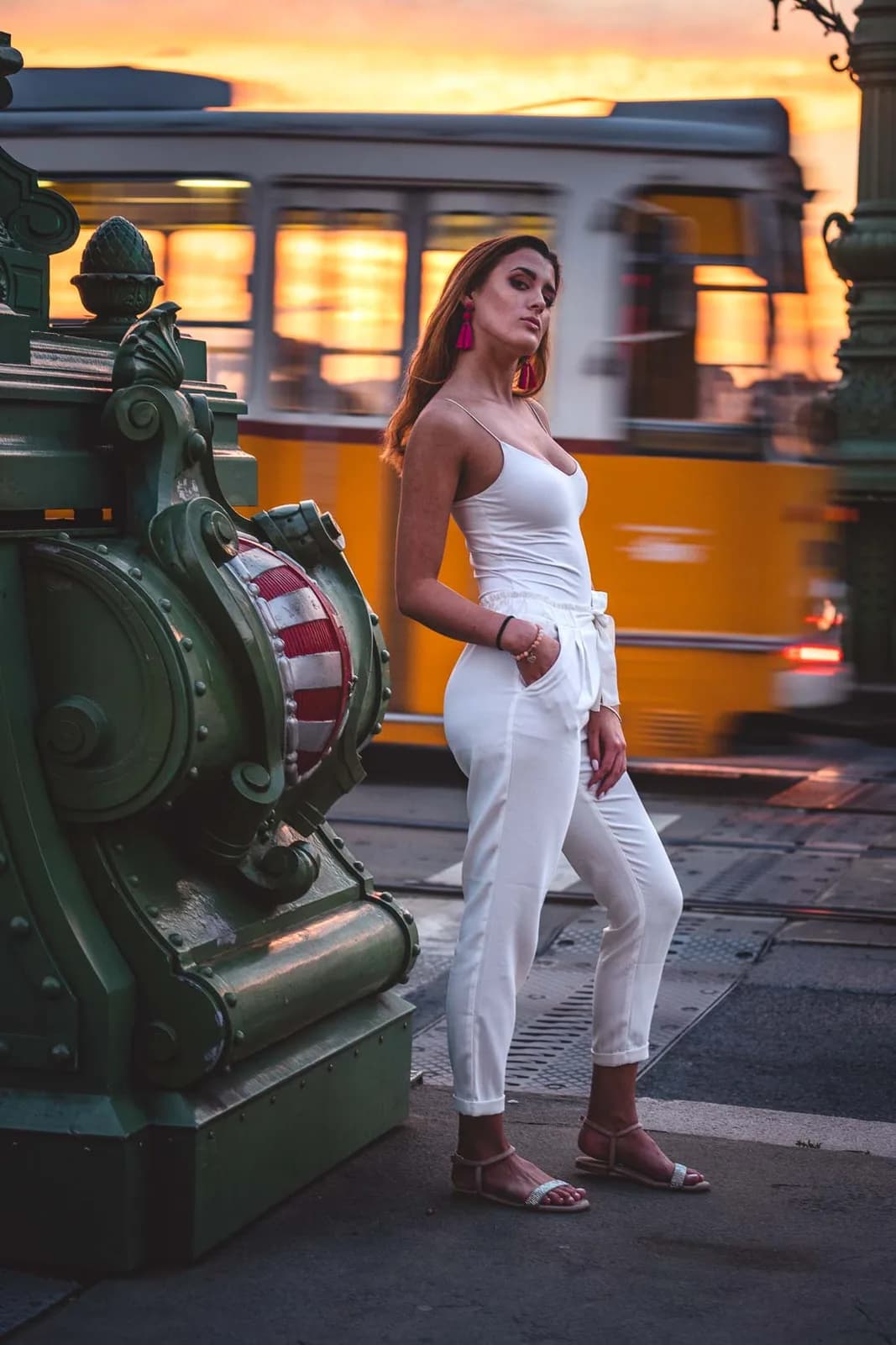 Femme en combinaison blanche devant un tramway jaune à Budapest
