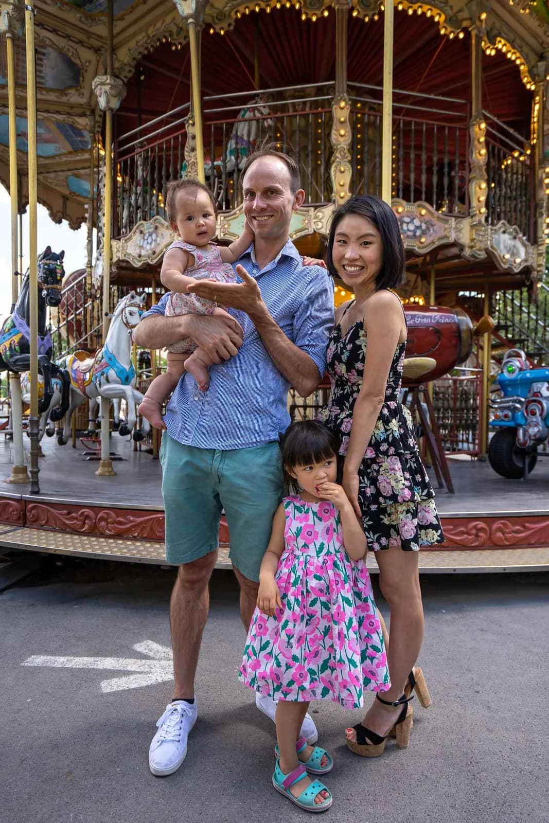Famille de quatre devant un manège dans un parc