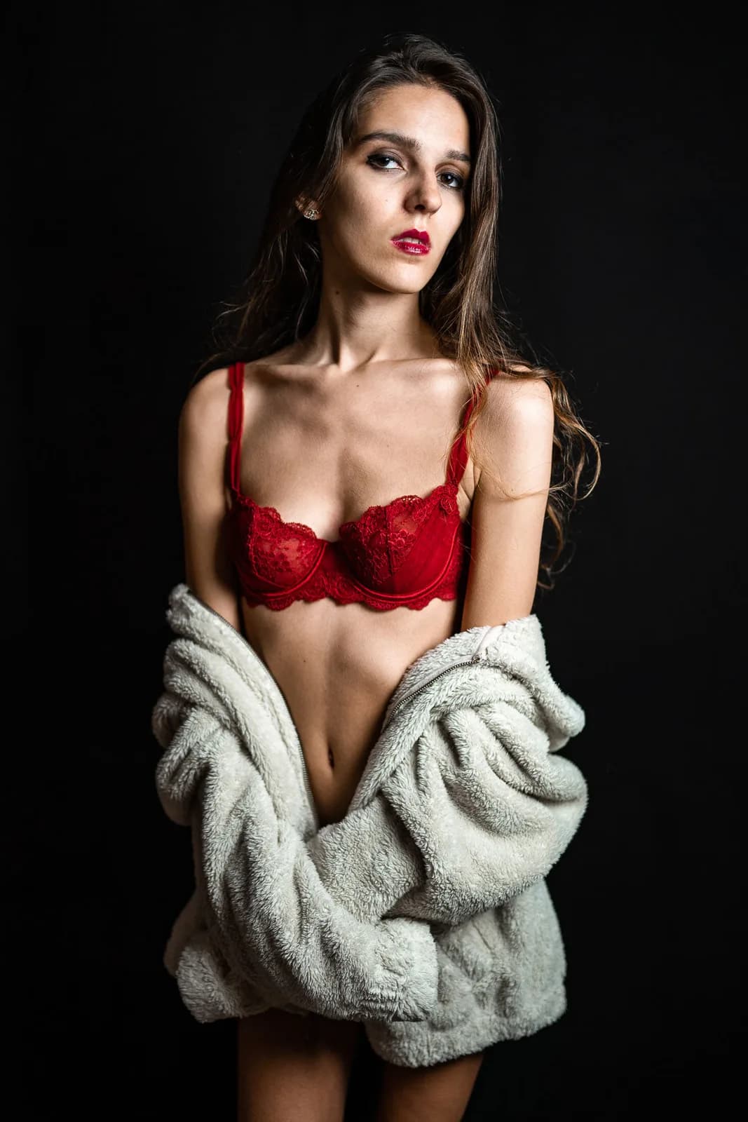 Modèle en soutien-gorge rouge et peignoir clair
