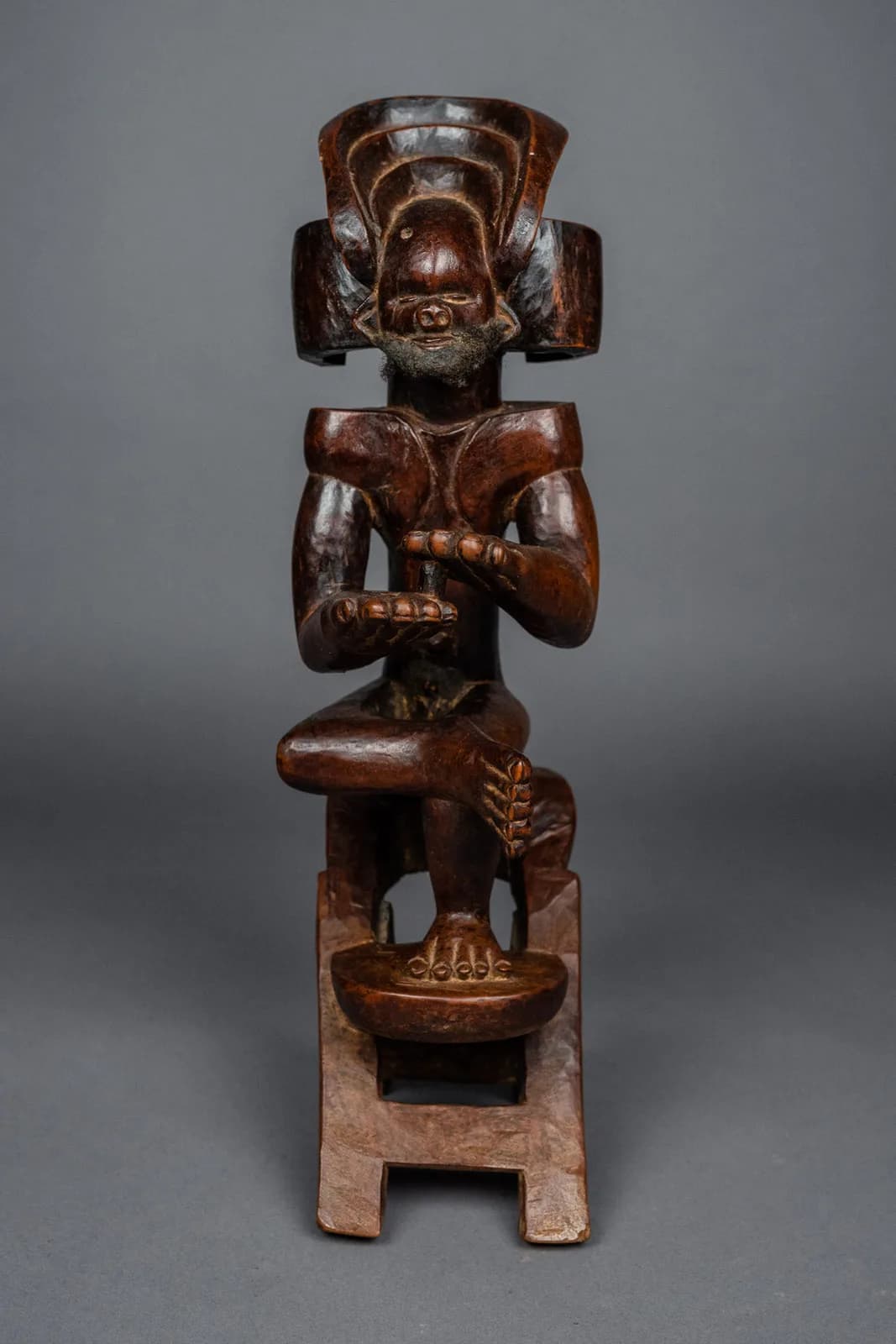 Statuette en bois représentant un personnage assis avec un tambour