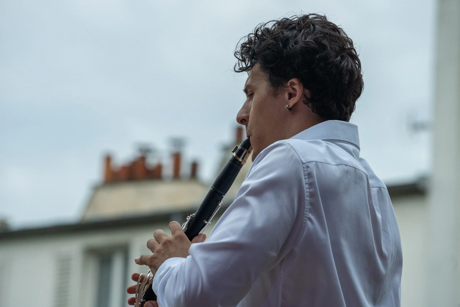 Clarinettiste en silhouette sur les cheminées parisiennes, Arènes musicales de Montmartre