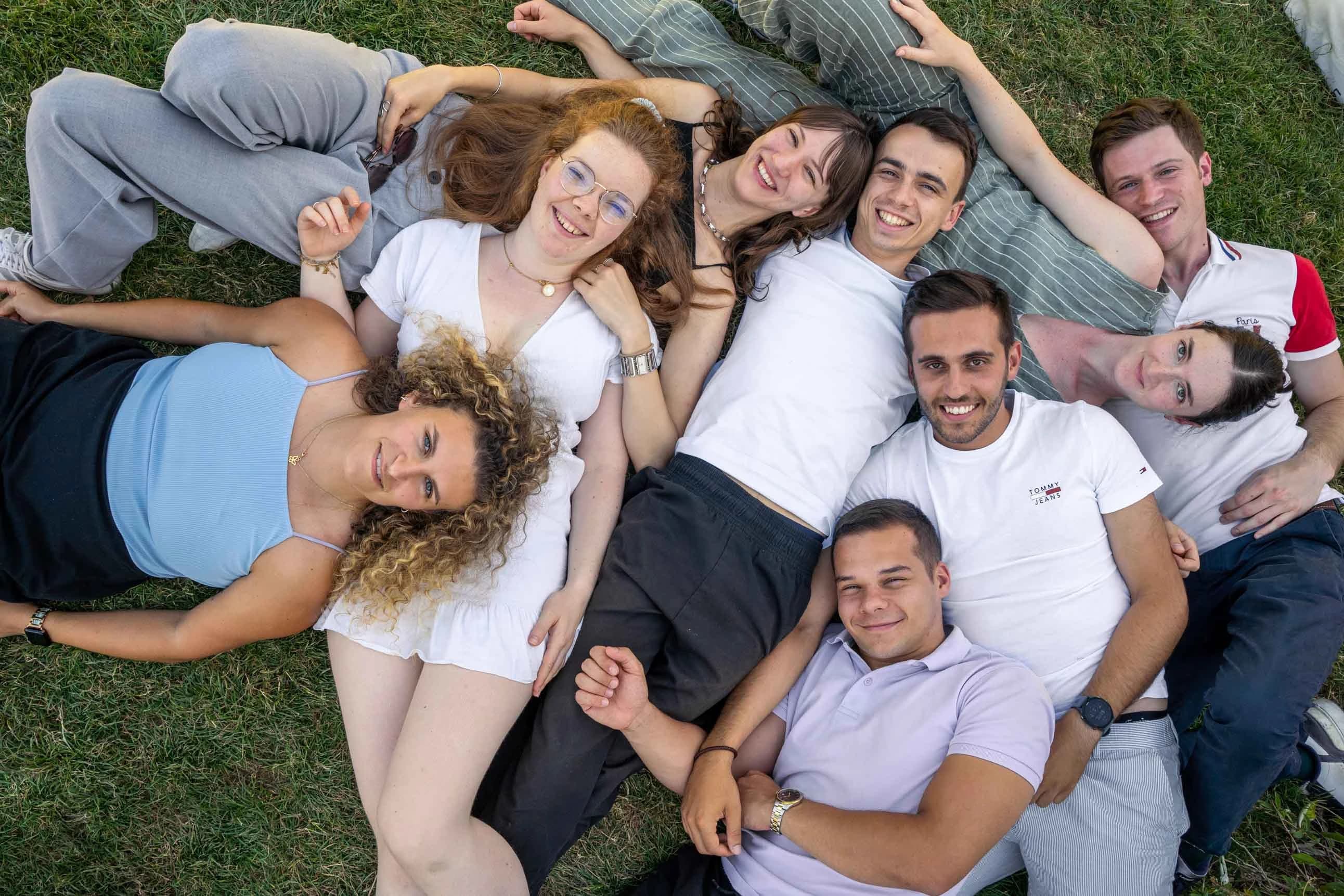 Group of friends lying in the grass, top view