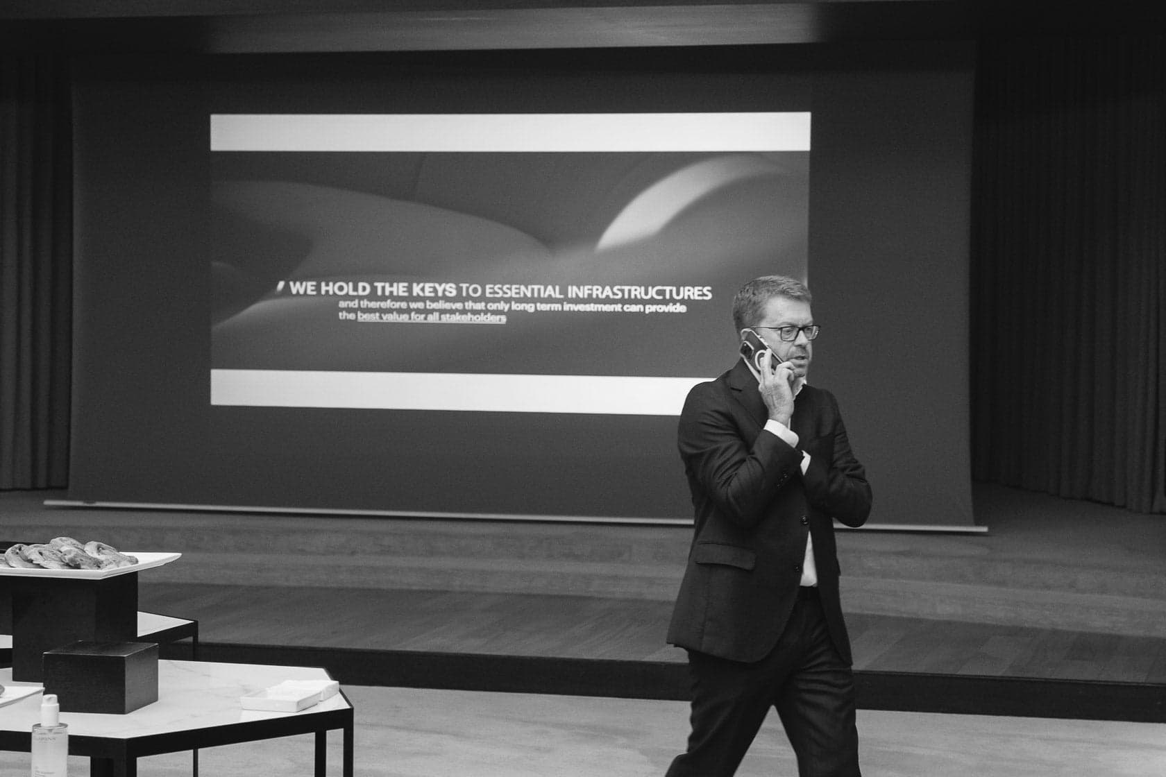 Invité en costume au téléphone pendant une conférence d'entreprise, noir et blanc