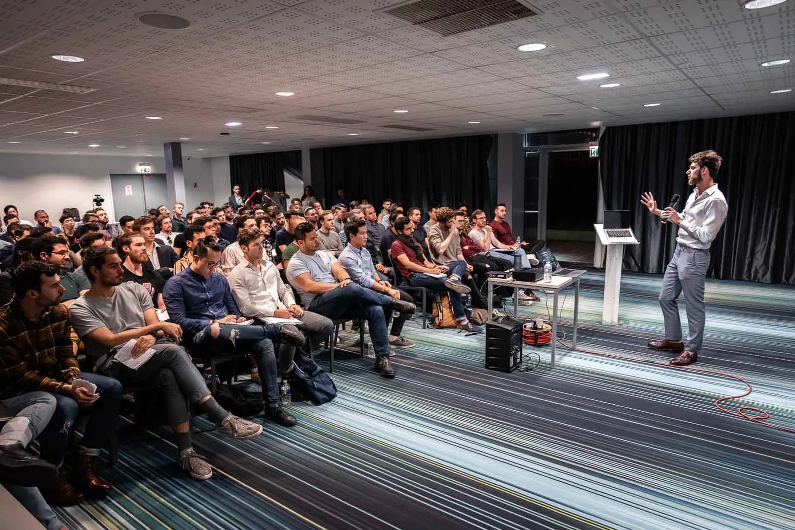 Orateur au micro face au public lors d un seminaire d'entreprise à Paris