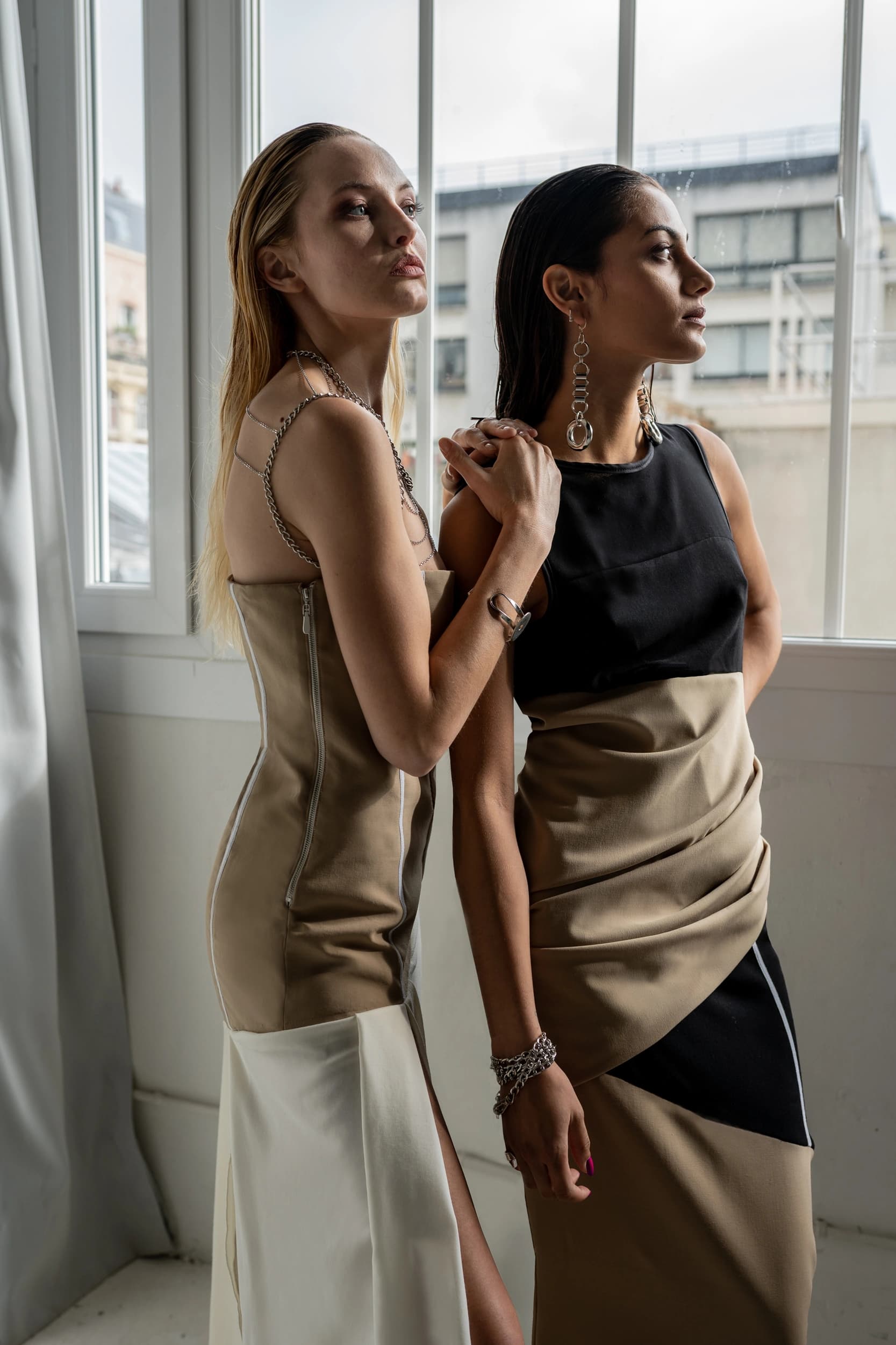 Duo de mannequins près d'une fenêtre en studio pendant un cours de prise de vue et de direction de modèle