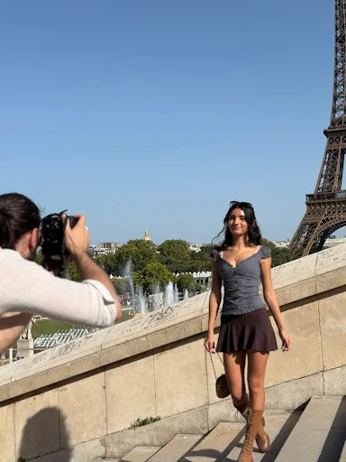 Le photographe Thibault Abraham en train de photographier une cliente devant la tour Eiffel depuis le Trocadéro