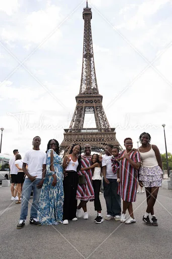 Photo de groupe familial de neuf personnes devant la tour Eiffel