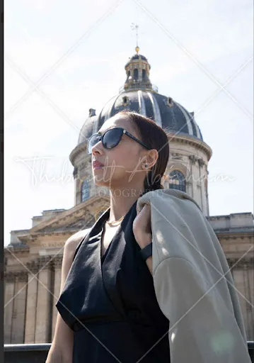 Portrait d'une femme en robe noire devant le dôme de l'Institut de France