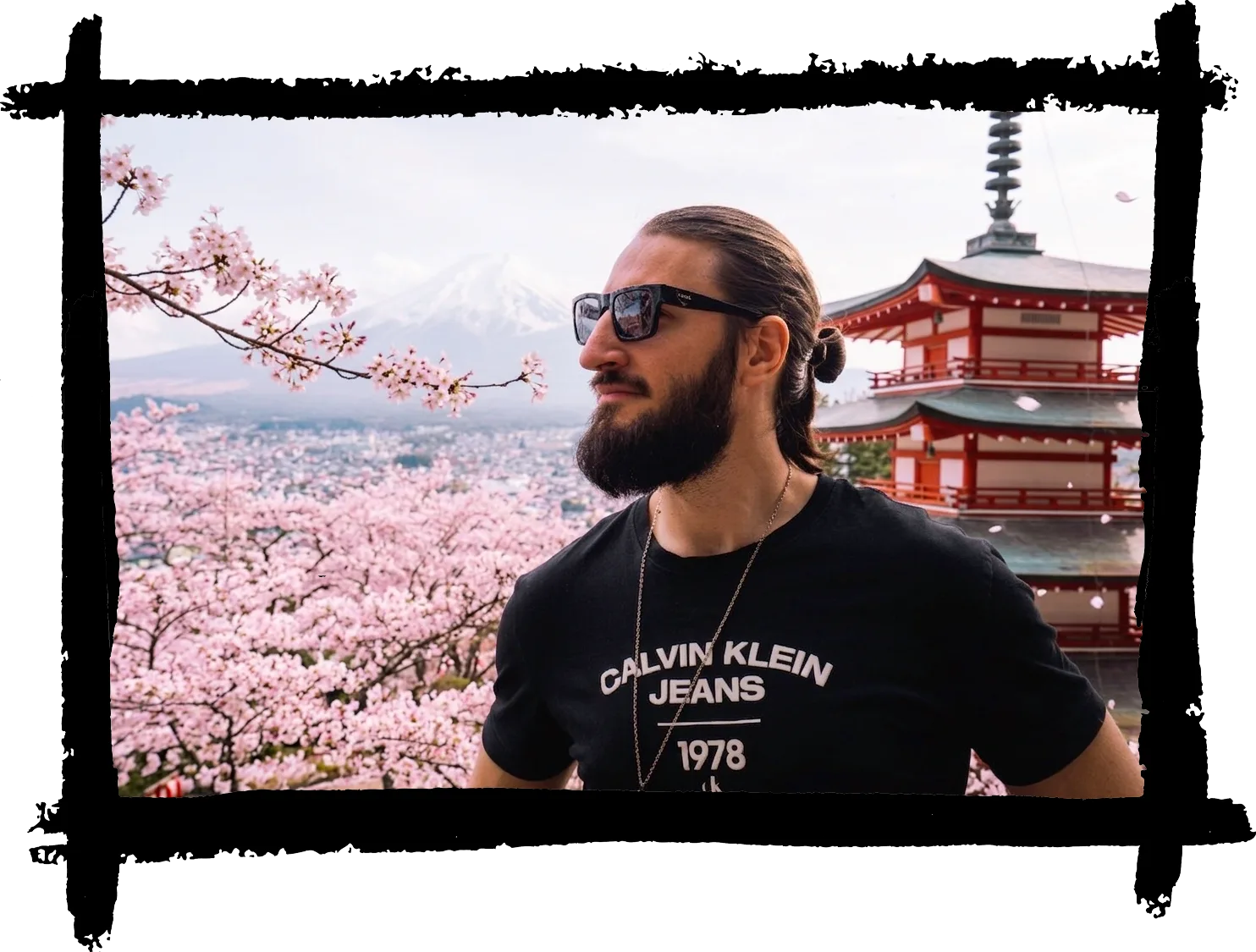 Portrait de Thibault Abraham devant une pagode japonaise, entouré de cerisiers en fleurs